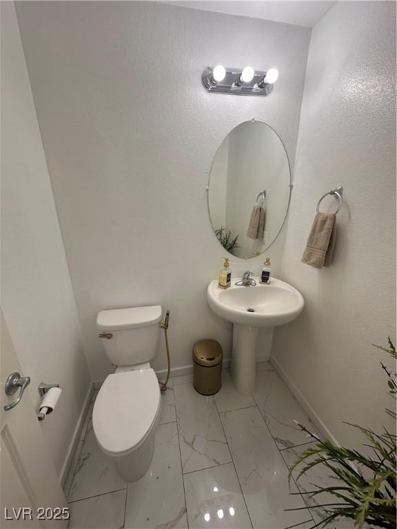 369 Stone Fly Rd, North Las Vegas, NV 89032 - bathroom with baseboards, marble finish flooring, toilet, and a sink