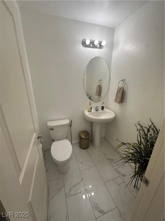 369 Stone Fly Rd, North Las Vegas, NV 89032 - bathroom featuring marble look tile flooring, toilet, and baseboards