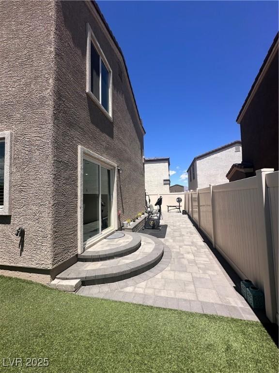 369 Stone Fly Rd, North Las Vegas, NV 89032 - back of house featuring fence, a patio area, and stucco siding