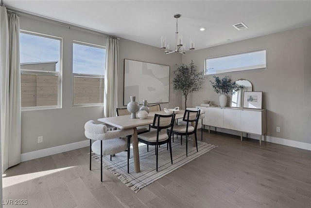 dining room with a chandelier, wood finished floors, baseboards, and recessed lighting