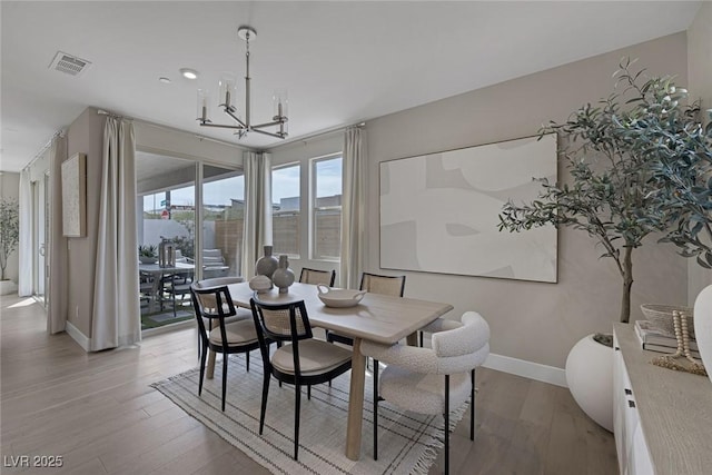 dining space with a chandelier, baseboards, wood finished floors, and recessed lighting