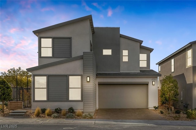 contemporary home with a garage, stucco siding, and driveway