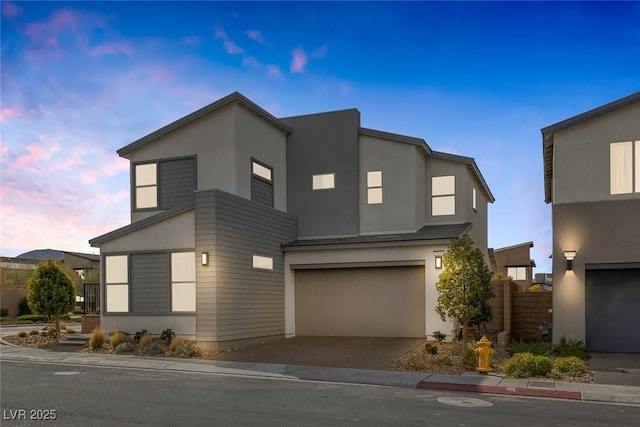 contemporary house featuring a garage, stucco siding, and driveway