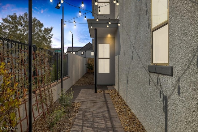 view of property exterior featuring stucco siding and fence