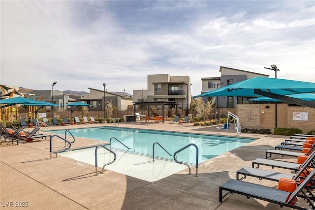 community pool with fence and a patio area