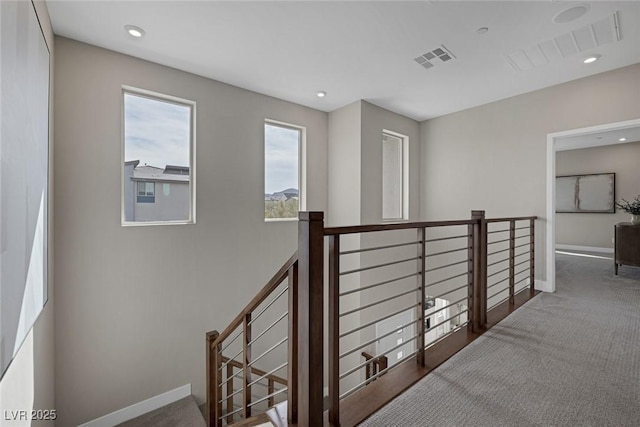 hallway with carpet, an upstairs landing, baseboards, and recessed lighting