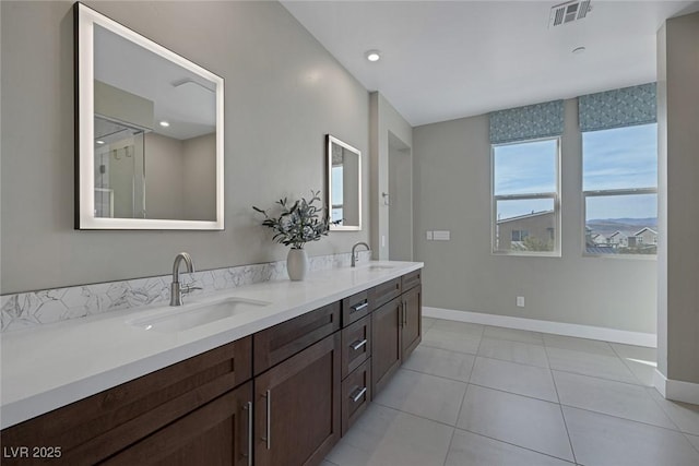 full bathroom with baseboards, double vanity, and tile patterned floors