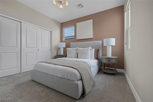 carpeted bedroom with a closet and baseboards