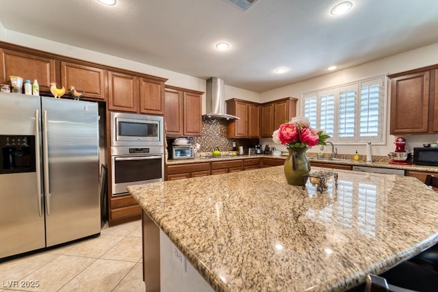 8137 Cape Flattery Ave, Las Vegas, NV 89147 - kitchen featuring stainless steel appliances, wall chimney range hood, a kitchen island, a sink, and light stone counters