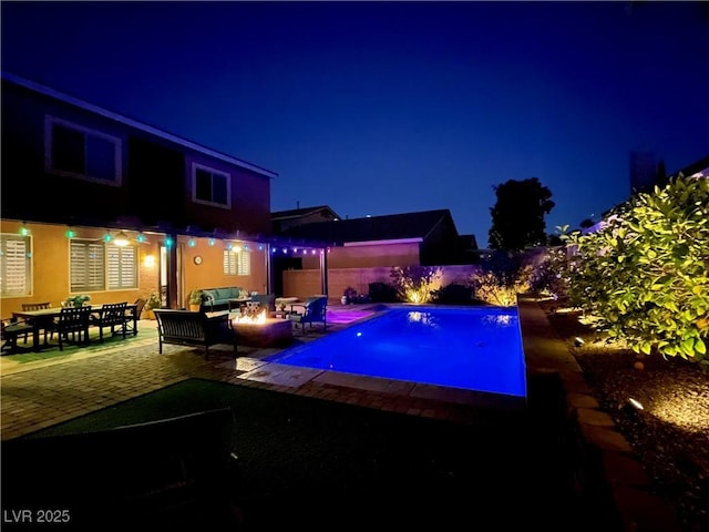 8137 Cape Flattery Ave, Las Vegas, NV 89147 - pool at twilight with a patio area, an outdoor living space with a fire pit, and a fenced backyard