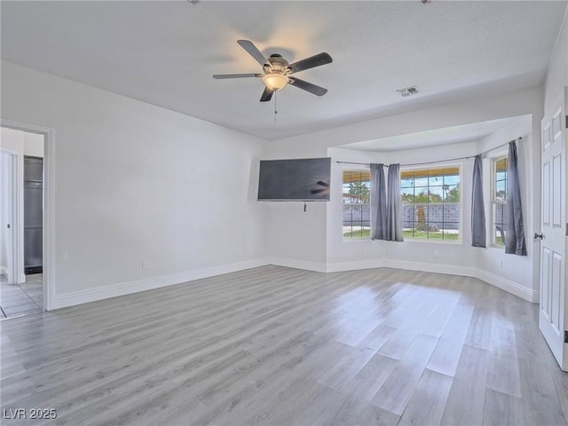 empty room featuring light wood-style flooring, a ceiling fan, and baseboards
