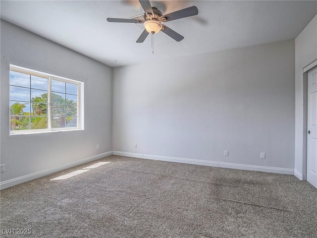 empty room with a ceiling fan, carpet floors, and baseboards