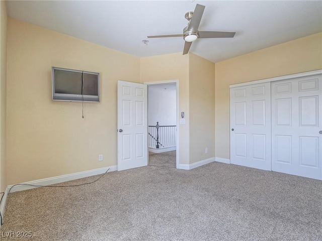 unfurnished bedroom with carpet, baseboards, a closet, and ceiling fan