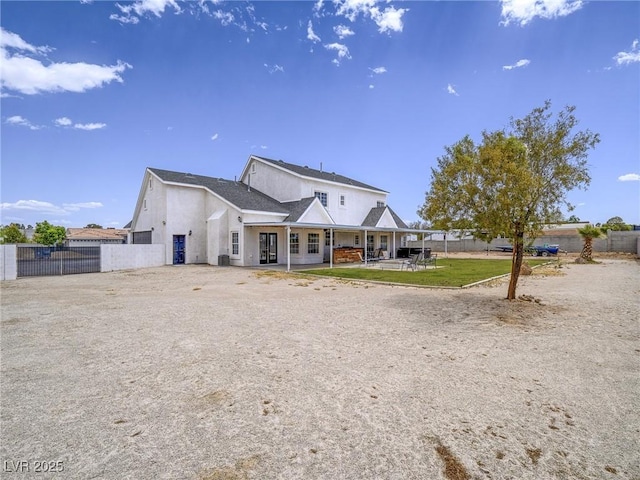 back of property featuring stucco siding, fence, and a patio