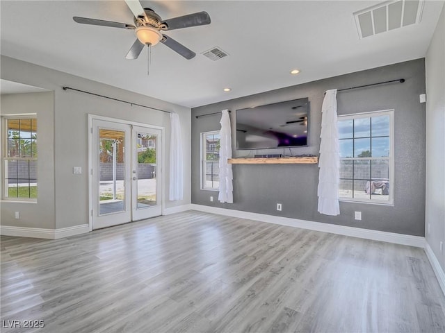 unfurnished living room with baseboards, plenty of natural light, wood finished floors, and recessed lighting