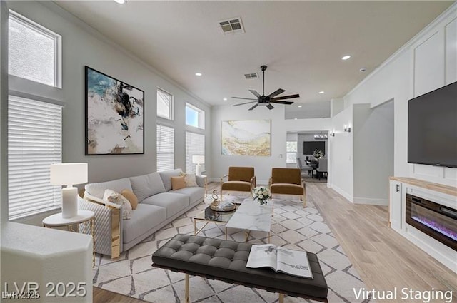 7460 Desert Flame Ct, Las Vegas, NV 89149 - living room featuring light wood-style floors, recessed lighting, ceiling fan, baseboards, and a glass covered fireplace