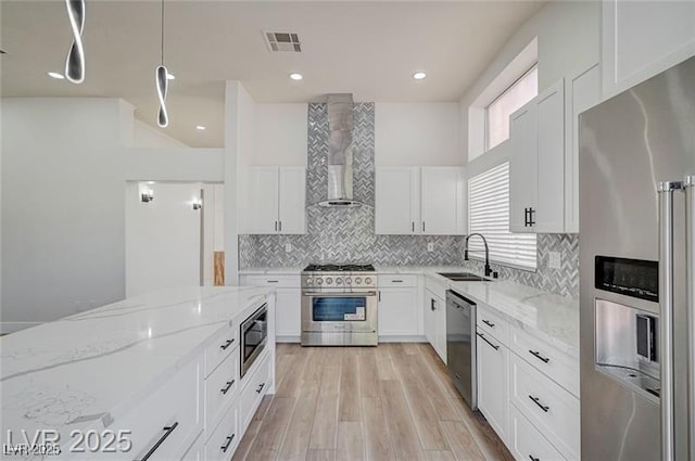 7460 Desert Flame Ct, Las Vegas, NV 89149 - kitchen featuring appliances with stainless steel finishes, a sink, wall chimney exhaust hood, and white cabinetry