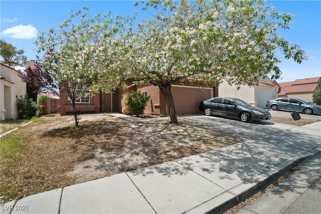 view of front of property with a garage, concrete driveway, and fence