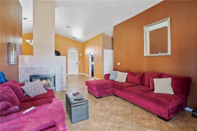 living area with tile patterned floors, a fireplace, and high vaulted ceiling