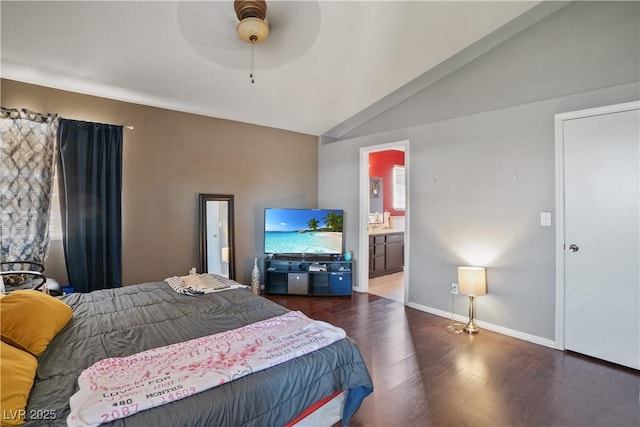 bedroom with wood finished floors, lofted ceiling, baseboards, and connected bathroom