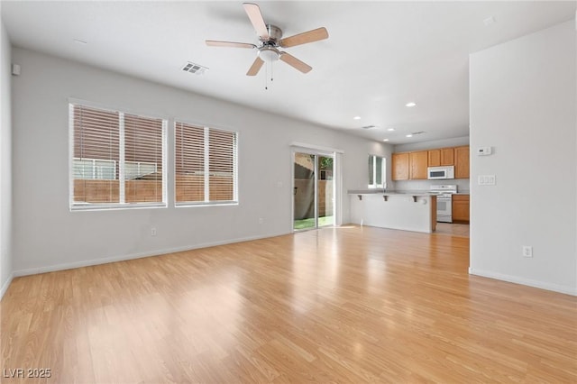 unfurnished living room with ceiling fan, baseboards, light wood-style floors, and recessed lighting