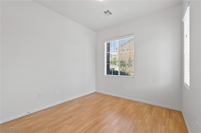 spare room with light wood-type flooring and baseboards