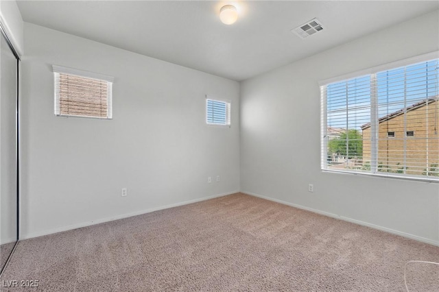carpeted spare room featuring baseboards
