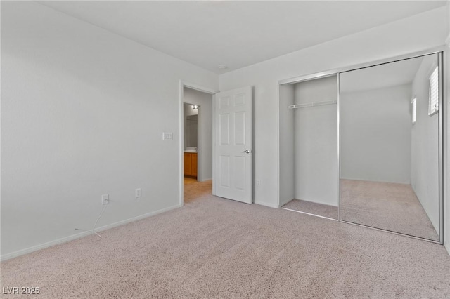 unfurnished bedroom with carpet floors, a closet, and baseboards