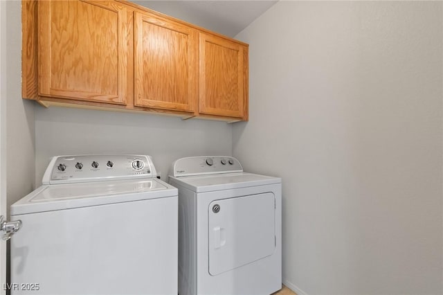 clothes washing area with cabinet space and separate washer and dryer