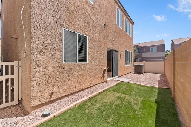 rear view of property featuring central AC unit and stucco siding
