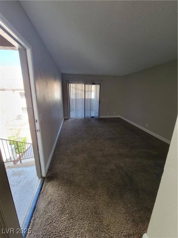 3151 Soaring Gulls Dr Unit 2101, Las Vegas, NV 89128 - empty room with dark carpet, healthy amount of natural light, baseboards, and a textured ceiling