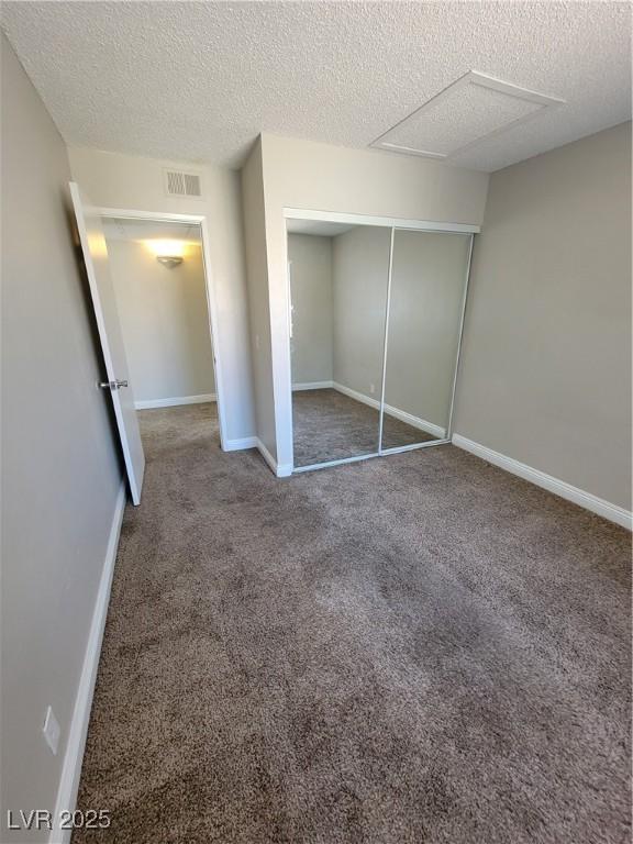 3151 Soaring Gulls Dr Unit 2101, Las Vegas, NV 89128 - unfurnished bedroom featuring a textured ceiling, carpet floors, a closet, and baseboards