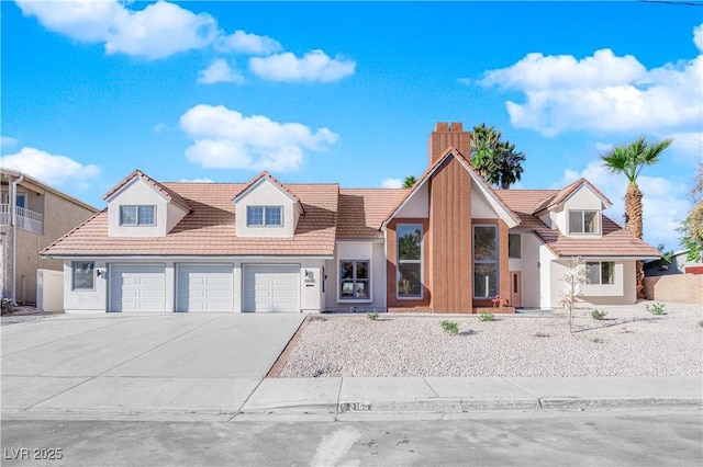 2160 Pueblo Cir, Las Vegas, NV 89169 - view of front of property featuring a chimney, concrete driveway, a tiled roof, and an attached garage