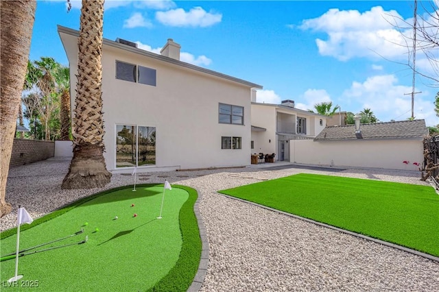 2160 Pueblo Cir, Las Vegas, NV 89169 - rear view of property with an area to practice putting, a patio area, stucco siding, fence, and a chimney