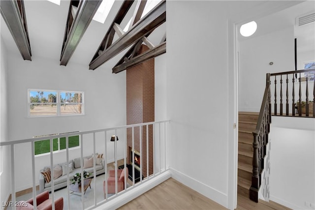 2160 Pueblo Cir, Las Vegas, NV 89169 - stairway with beamed ceiling, wood finished floors, a skylight, baseboards, and a high ceiling