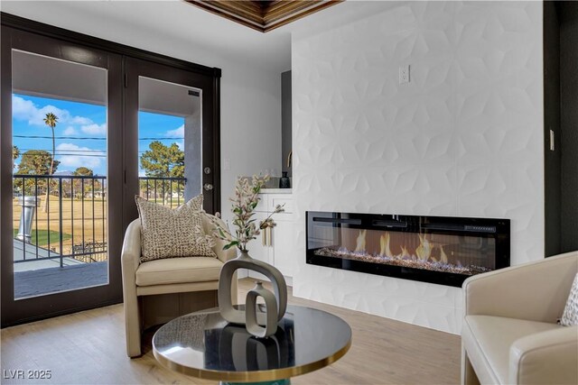 2160 Pueblo Cir, Las Vegas, NV 89169 - sitting room with healthy amount of natural light, a glass covered fireplace, wood finished floors, and ornamental molding