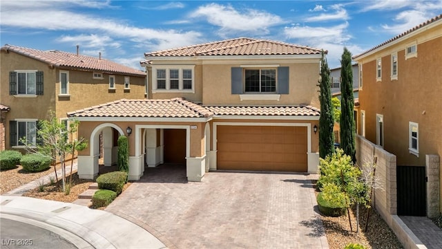 view of front of house featuring a tiled roof, stucco siding, decorative driveway, and a garage