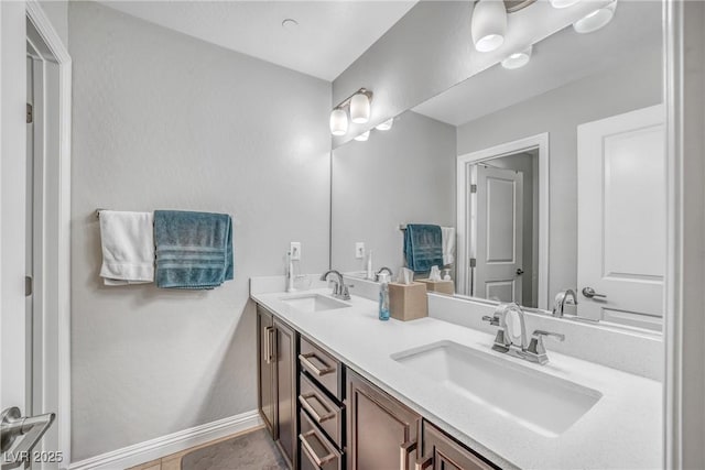 full bathroom with baseboards and double vanity