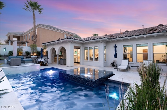 10717 Beringer Dr, Las Vegas, NV 89144 - back of house at dusk featuring an outdoor living space, stucco siding, and a patio area