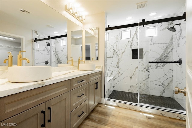 8095 Carpenter Creek Ave, Las Vegas, NV 89113 - bathroom featuring a marble finish shower, wood finished floors, double vanity, and recessed lighting