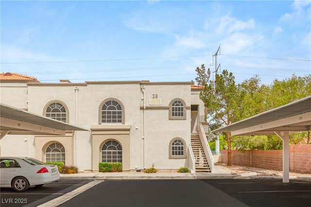 3125 N Buffalo Dr Unit 1103, Las Vegas, NV 89128 - view of building exterior featuring stairs, covered parking, and fence