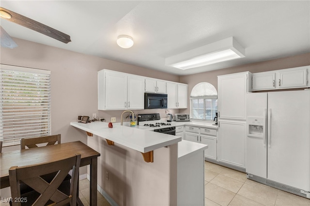3125 N Buffalo Dr Unit 1103, Las Vegas, NV 89128 - kitchen featuring white appliances, a peninsula, white cabinets, and a kitchen bar