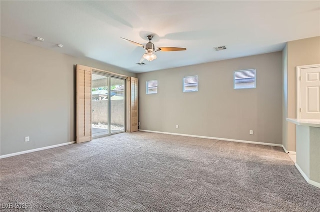 carpeted empty room featuring ceiling fan, healthy amount of natural light, and baseboards