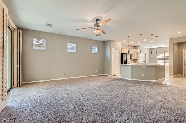 unfurnished living room with light carpet, recessed lighting, ceiling fan, baseboards, and plenty of natural light