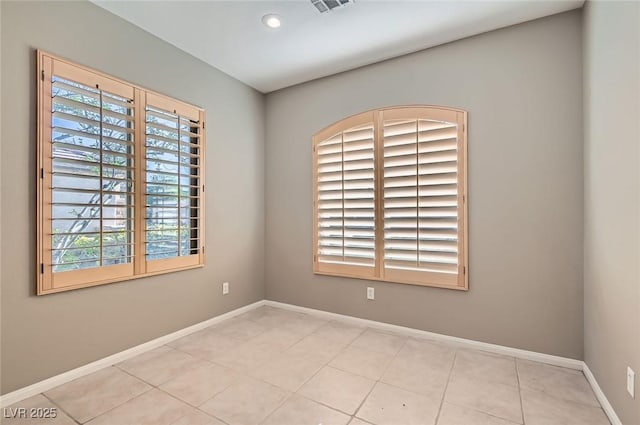 tiled empty room with baseboards and recessed lighting