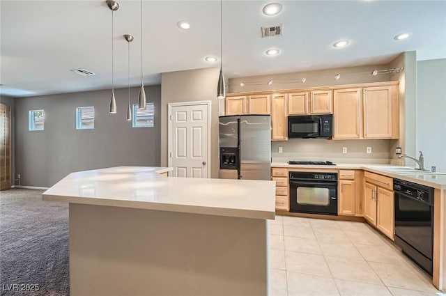 kitchen with black appliances, light brown cabinetry, a sink, light countertops, and pendant lighting
