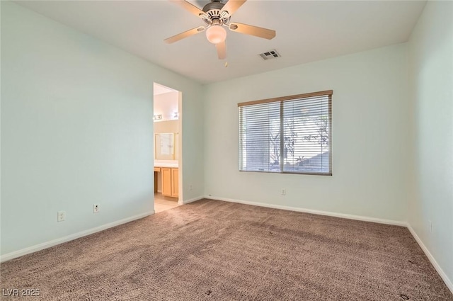 empty room featuring light colored carpet, ceiling fan, and baseboards