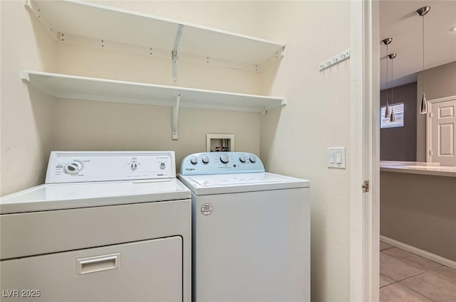 laundry room featuring independent washer and dryer, light tile patterned flooring, and baseboards