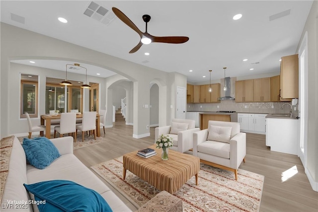 177 Rocky Star St, Henderson, NV 89012 - living room with arched walkways, ceiling fan, light wood-style floors, recessed lighting, and baseboards
