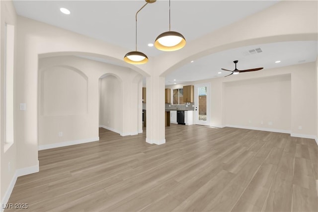 177 Rocky Star St, Henderson, NV 89012 - unfurnished living room with ceiling fan, arched walkways, recessed lighting, baseboards, and light wood finished floors
